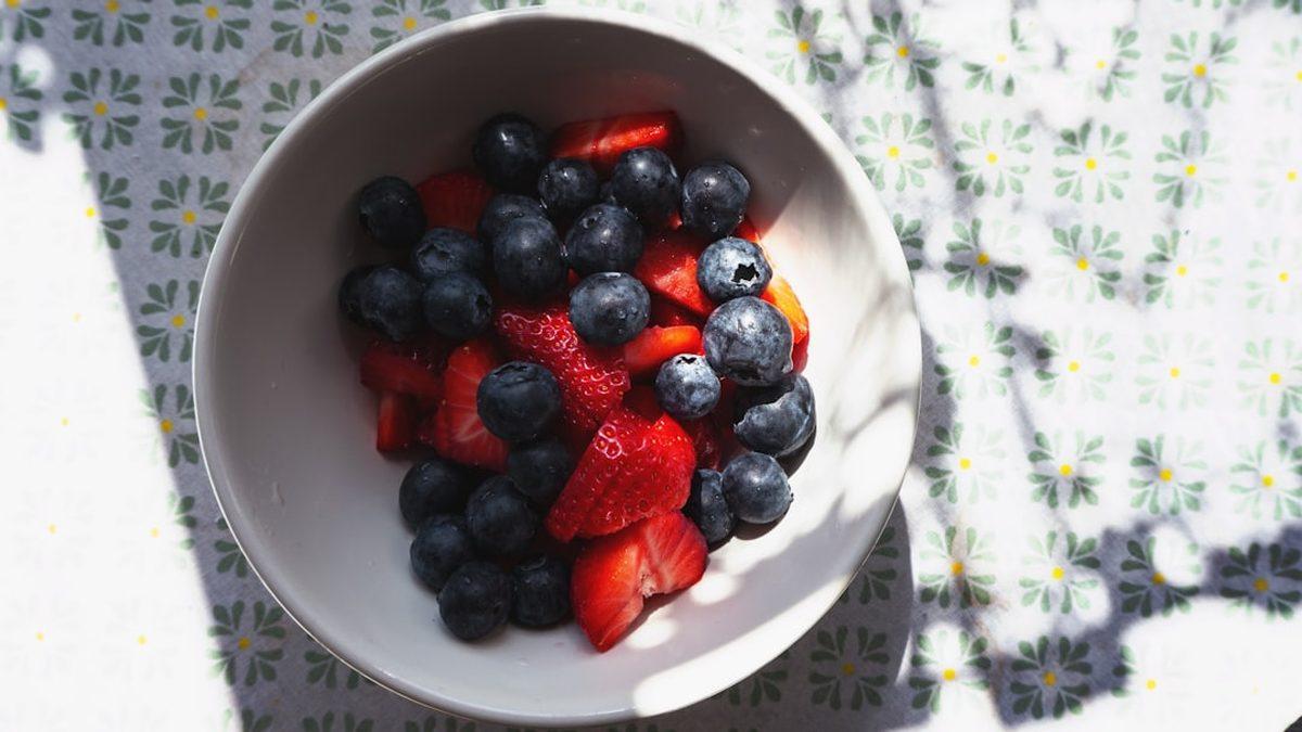 nutrient dense foods for small appetites — berry smoothie bowl with nuts and seeds in morning light