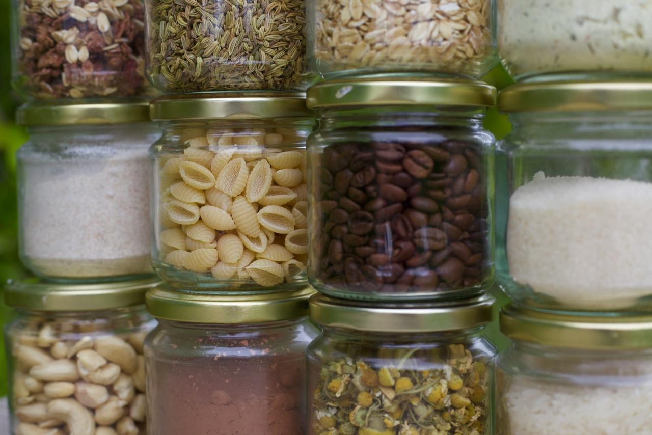 plant-based pantry staples that save money — colorful dried legumes and whole grains in glass containers